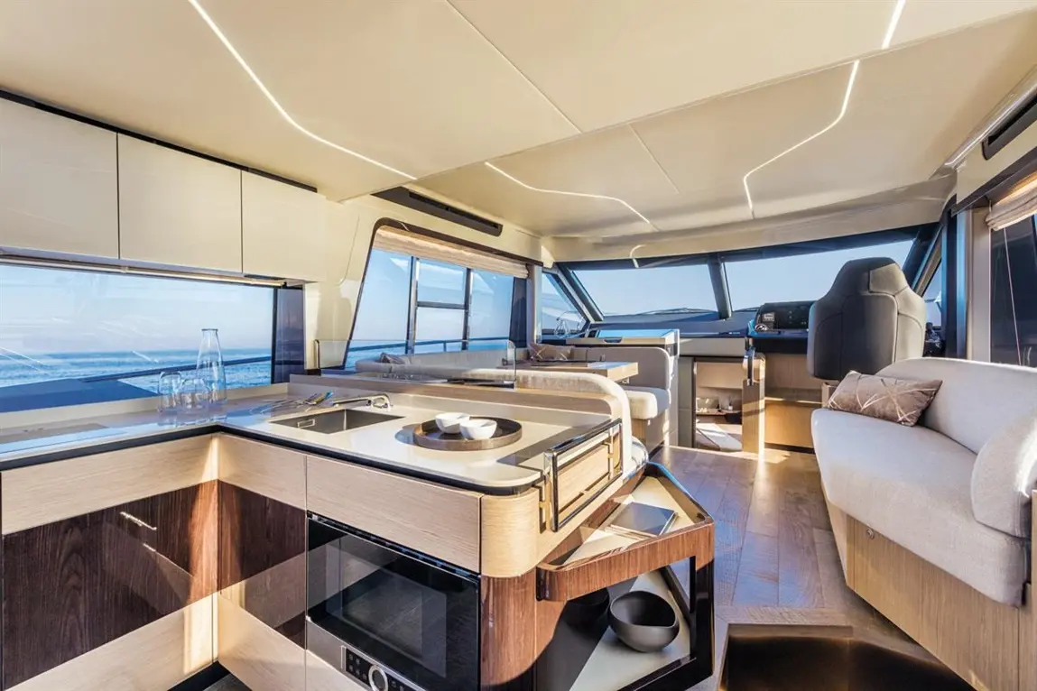 Modern yacht interior featuring a sleek kitchen, panoramic windows, and a stylish lounge area with elegant furnishings.